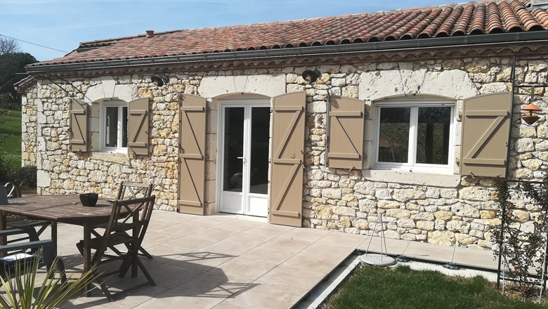 Photo de volets battants de couleur marron installés sur les fenêtres et la porte fenêtre d'une maison Photo de volets battants de couleur marron installés sur les fenêtres et la porte fenêtre d'une maison